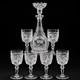 A vintage cut crystal decanter and six wine glasses with etched cherry motifs